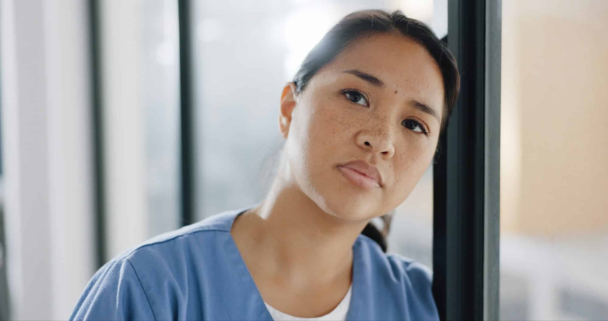 Woman, depression and sad nurse in hospital after loss, failure or bad news. Stressed, mental healt